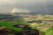 Regenboog over akkers en weilanden