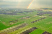 Regenboog over akkers en weilanden